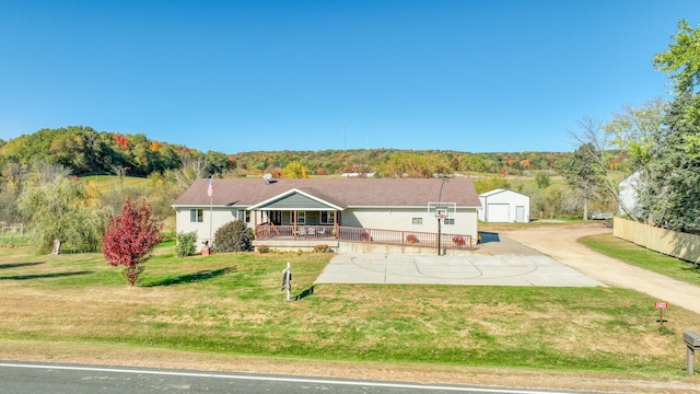 single story home featuring a shed, covered porch, and a front yard