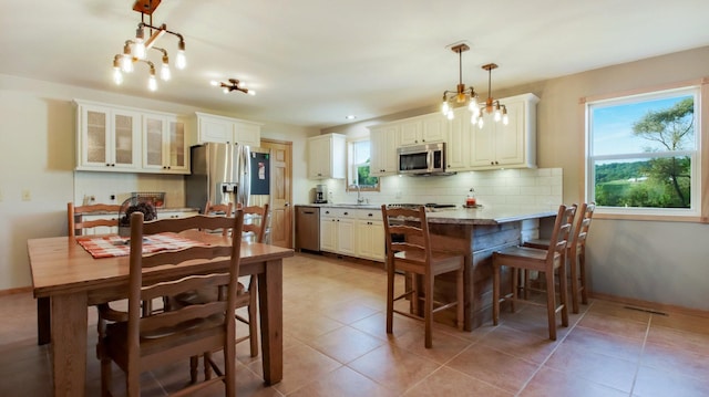 dining space with sink and light tile patterned floors