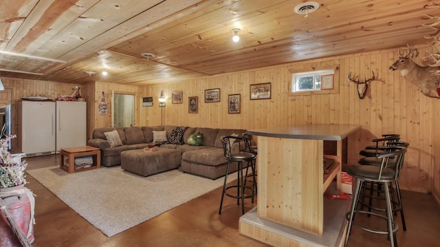 living room featuring indoor bar, wooden walls, concrete floors, and wooden ceiling