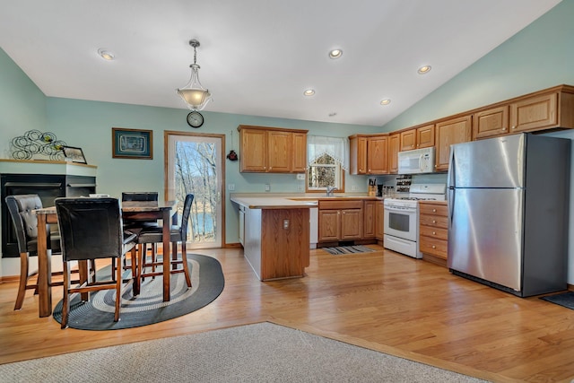 kitchen featuring light hardwood / wood-style floors, appliances with stainless steel finishes, lofted ceiling, pendant lighting, and a center island