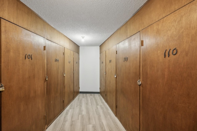 hallway featuring light wood-style floors and a textured ceiling