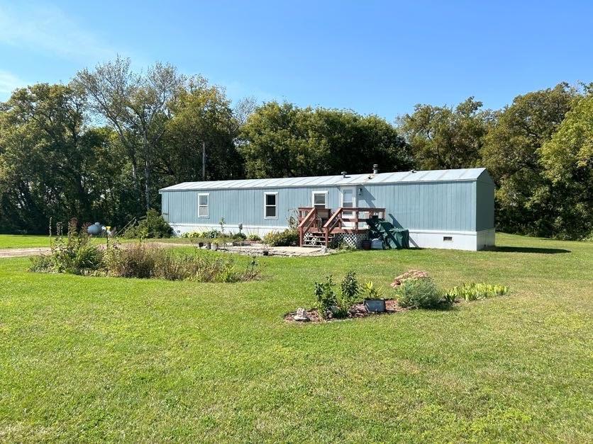 view of front of home featuring a front lawn and an outbuilding