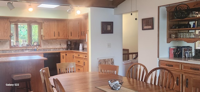 kitchen featuring tasteful backsplash, black dishwasher, and sink