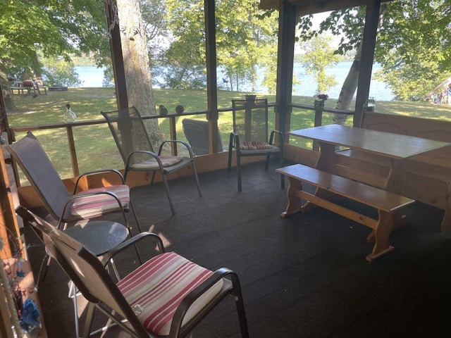 sunroom featuring a water view