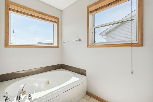 bathroom with tile patterned flooring, a healthy amount of sunlight, and a tub to relax in