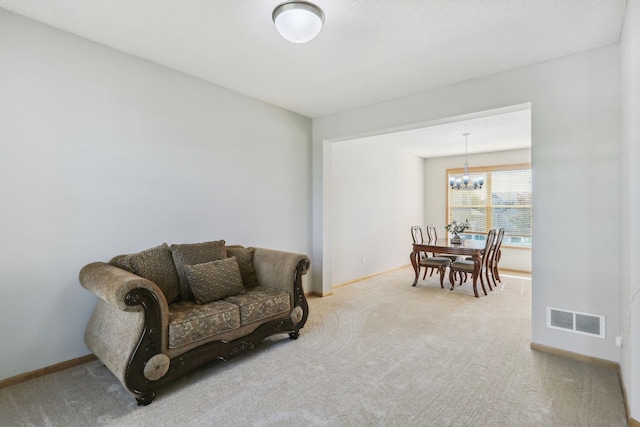 living area with light colored carpet and a chandelier