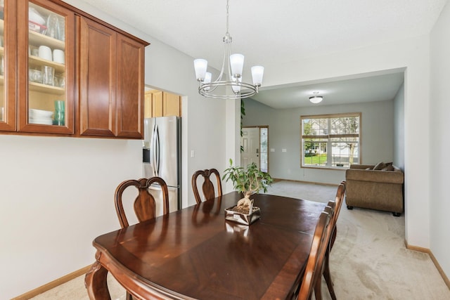 dining space with light colored carpet and a chandelier