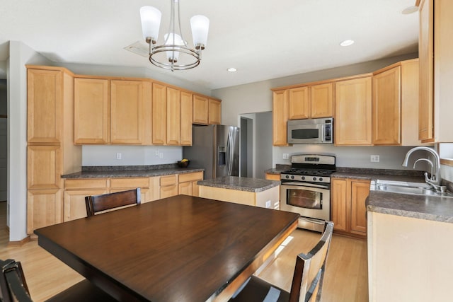 kitchen with sink, hanging light fixtures, light brown cabinets, light hardwood / wood-style flooring, and appliances with stainless steel finishes