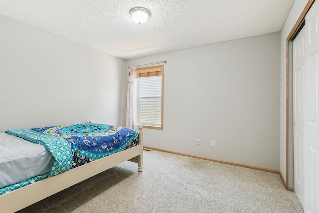 bedroom featuring carpet, a closet, and a textured ceiling