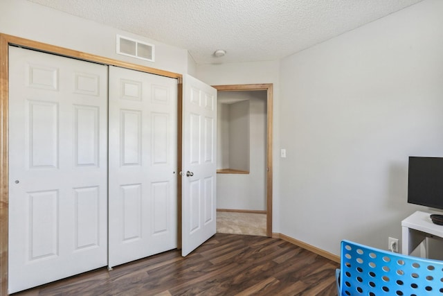 unfurnished office with dark hardwood / wood-style floors and a textured ceiling