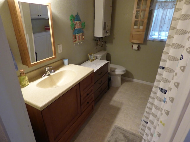 bathroom featuring water heater, vanity, and toilet