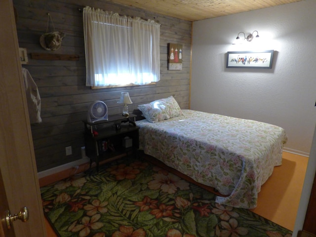 bedroom with wood ceiling and wood walls