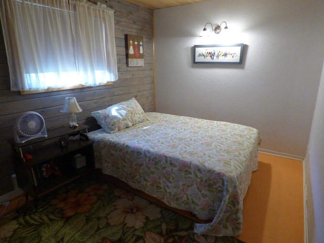 bedroom featuring wooden walls