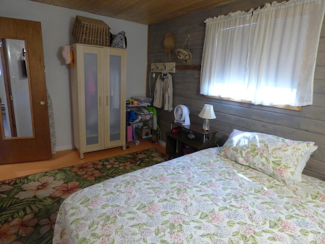 bedroom with wood ceiling and wooden walls