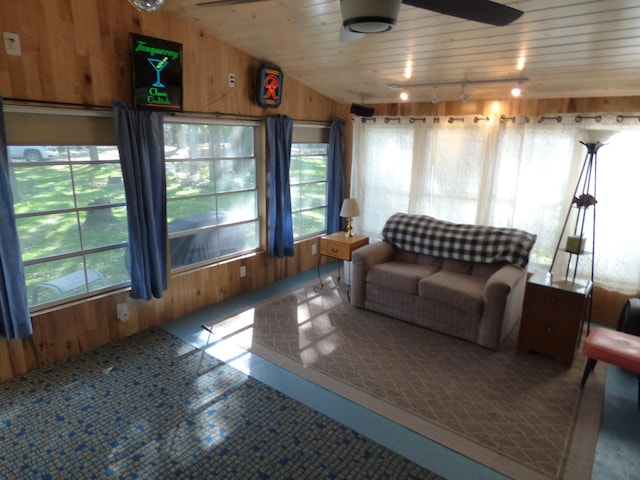 living room with wood ceiling, wood walls, ceiling fan, and track lighting