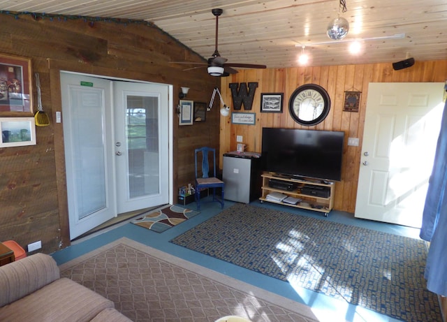 living room featuring wood ceiling, lofted ceiling, wood walls, and ceiling fan