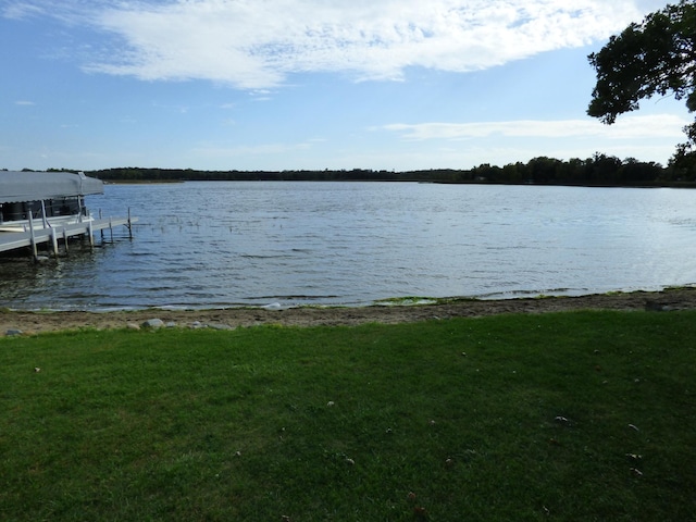 dock area with a water view and a yard