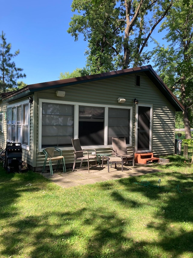 back of property featuring a patio area and a yard