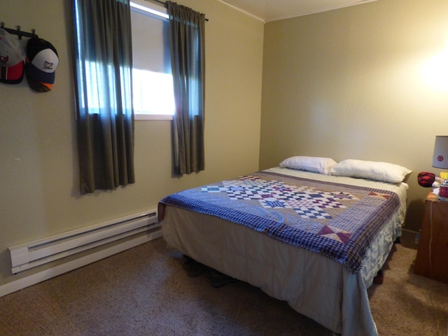 bedroom with carpet floors and a baseboard heating unit