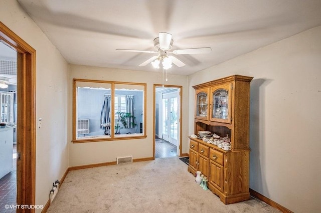 interior space featuring ceiling fan and light colored carpet