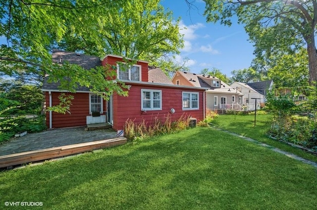 rear view of property with a yard and a deck