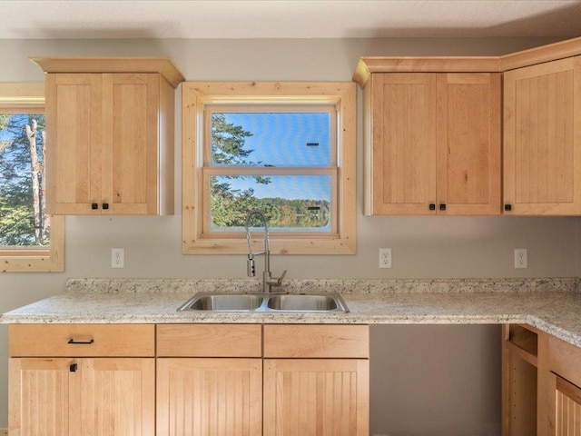 kitchen with light brown cabinets, a sink, and light countertops