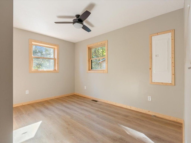 spare room featuring electric panel, ceiling fan, and light hardwood / wood-style flooring