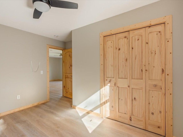 unfurnished bedroom with ceiling fan, baseboards, and light wood-style flooring