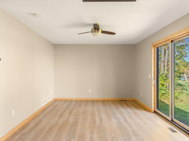 spare room with baseboards, a ceiling fan, visible vents, and light wood-type flooring