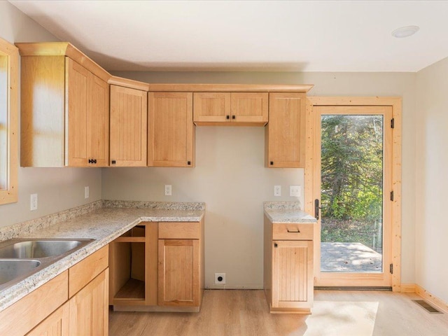 kitchen with light countertops, light wood finished floors, visible vents, and light brown cabinetry