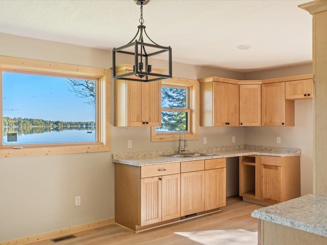 kitchen with light brown cabinets, visible vents, and light wood-style floors