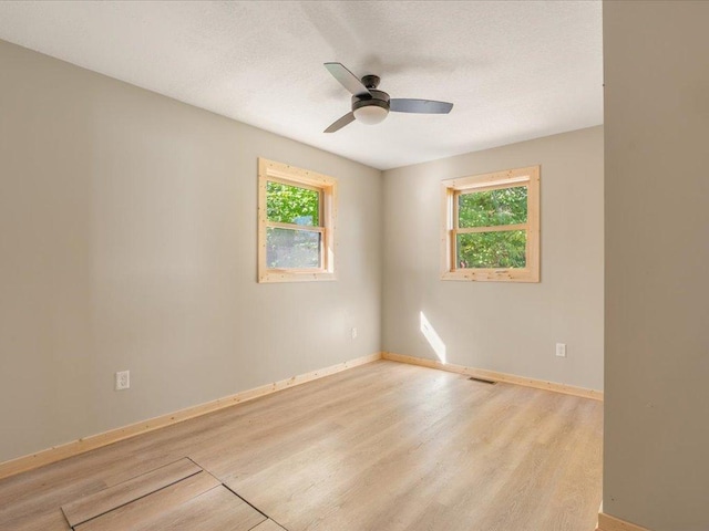 empty room with ceiling fan, baseboards, and light wood-style flooring