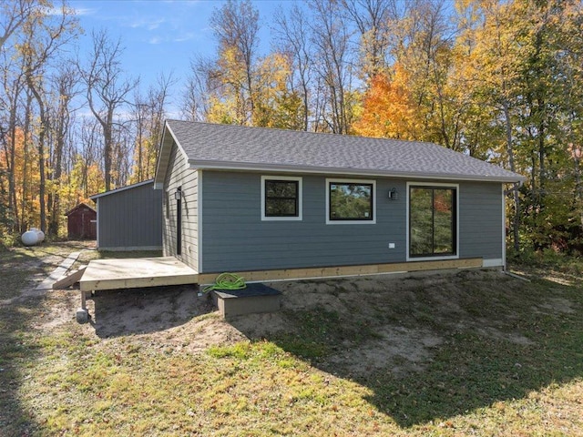 rear view of house with a shingled roof
