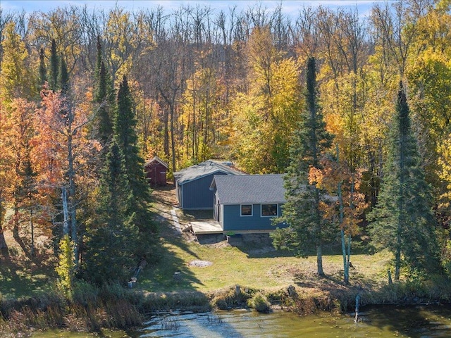 drone / aerial view with a wooded view and a water view