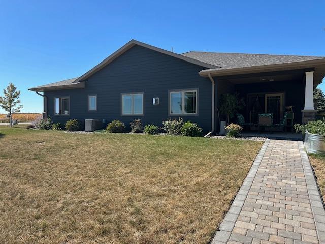 ranch-style home featuring a front lawn and central AC