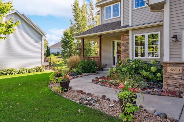 entrance to property with a porch and a yard