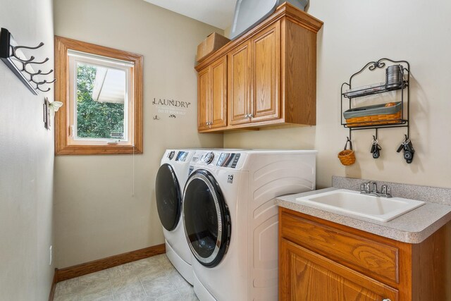 clothes washing area featuring cabinets, light tile patterned flooring, washer and clothes dryer, and sink