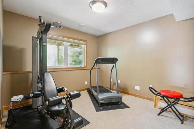 exercise area with carpet floors and a textured ceiling