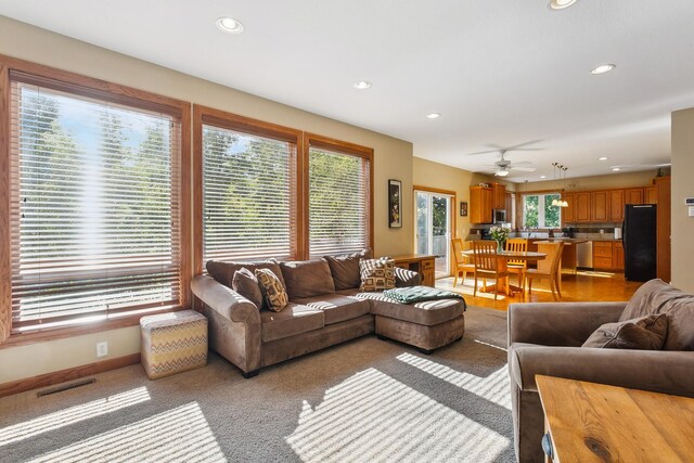 living room featuring light carpet and ceiling fan