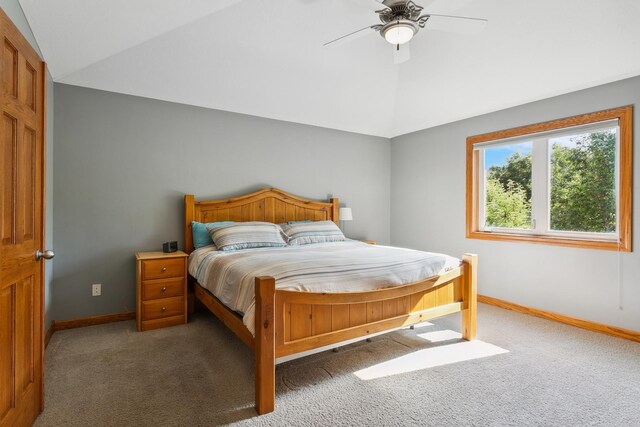 bedroom with ceiling fan, lofted ceiling, and dark colored carpet