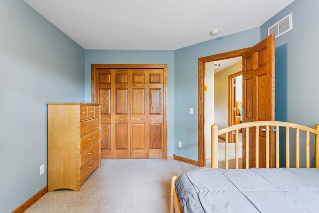 bedroom featuring a closet and light colored carpet