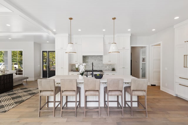 kitchen with a spacious island, pendant lighting, light wood-type flooring, and a kitchen bar