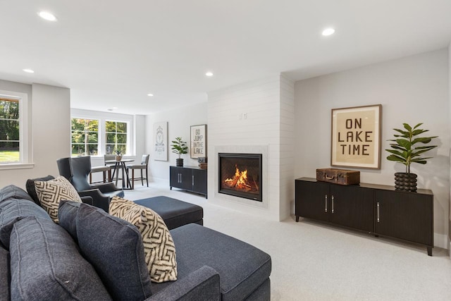 living room with a fireplace and light carpet