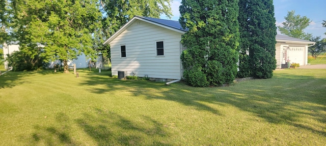 view of side of property with cooling unit, a yard, and a garage