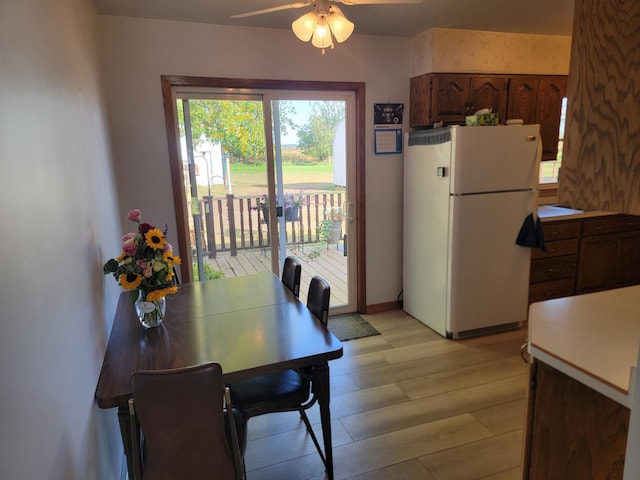 dining space featuring light wood-type flooring and ceiling fan