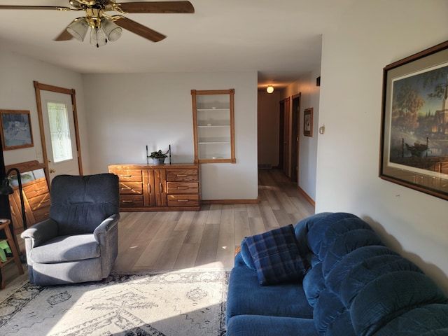 living room with light wood-type flooring and ceiling fan