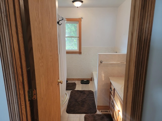 bathroom with a bath, tile patterned flooring, and vanity