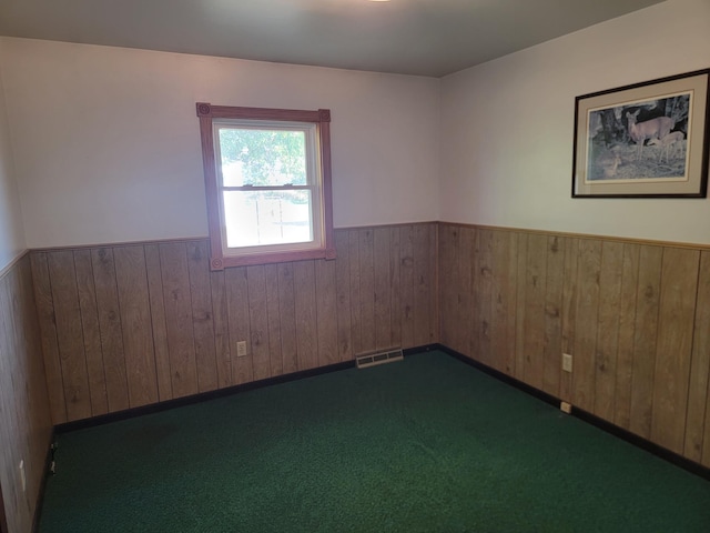 carpeted empty room with wooden walls