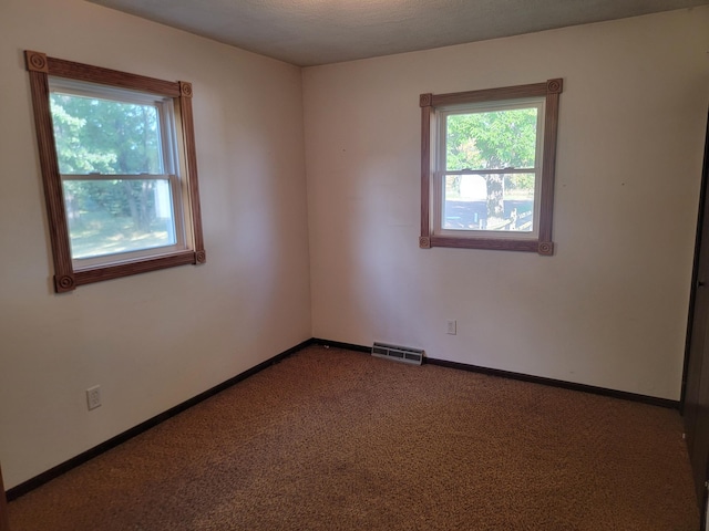 empty room with a textured ceiling and carpet flooring