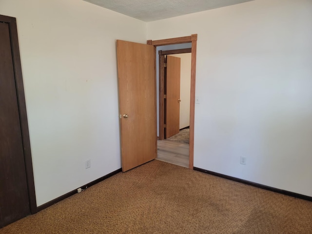 unfurnished room with a textured ceiling and carpet flooring